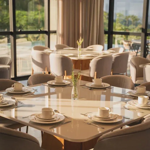 Mesa posta com louças brancas e luz do fim de tarde